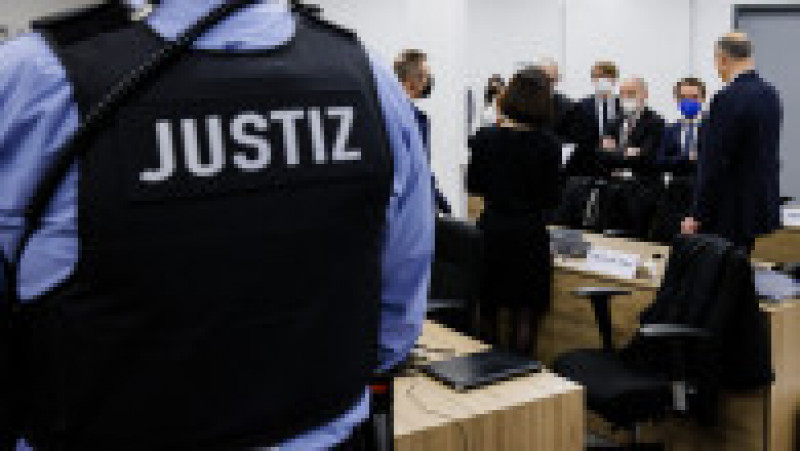 28 January 2022, Saxony, Dresden: A court employee and defense lawyers stand in the courtroom of the Dresden Higher Regional Court before the trial on the jewel heist in the Green Vault of Dresden