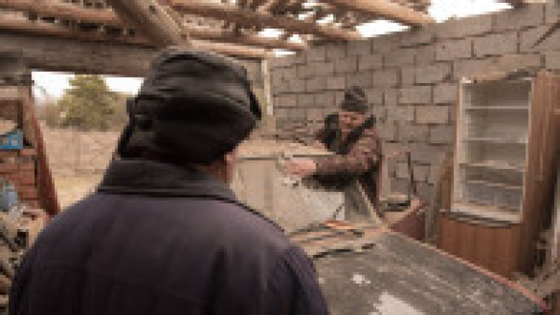 Localnicii din estul Ucrainei, din localitatea Stanița Lugansk, evaluează pagubele provocate de bombardamentele din ultimele zile. Foto: Profimedia | Poza 2 din 13