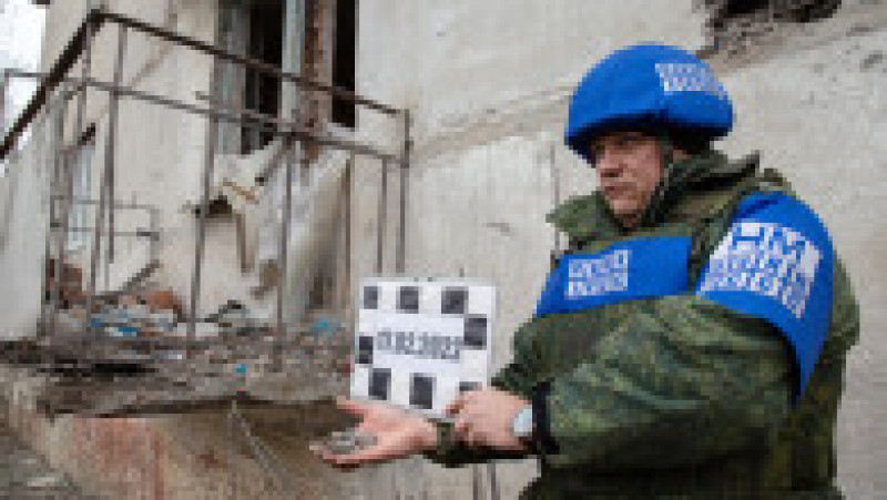 Soldat al autoproclamatei Republici Populare Lugansk prezintă schije ale bombardamentelor care au avut loc în satul Mikolaivka. Foto: Profimedia | Poza 12 din 13