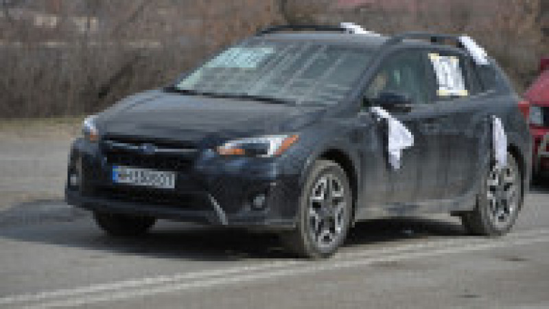 Ucrainenii leagă și panglici albe de mașină, ca să arate intențiile pașnice. Foto: Profimedia | Poza 7 din 13