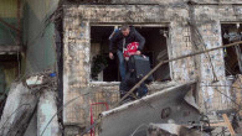 Bărbat cu un bagaj care iese dintr-o clădire distrusă de bombardamente, în Kiev. Foto: Profimedia Images | Poza 2 din 5