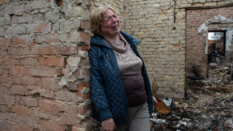 O ucraineană dintr-o localitate din jurul Kievului plânge când se întoarce să-și vadă casa după bombardamentele rușilor. Foto: Getty Images