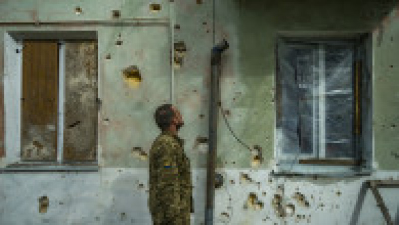 Un soldat se uită la gloanțele care au ciuruit un bloc de locuințe din Nikolaev. Foto: Profimedia Images | Poza 8 din 12