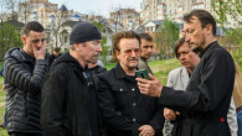 Preotul Andrii Holovine le arată lui Bono și lui The Edge imagini cu ororile de la Bucha Foto: Profimedia Images | Poza 11 din 18
