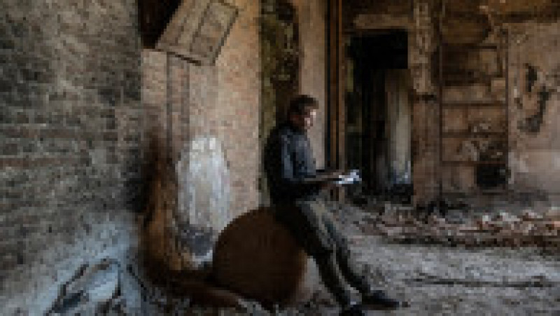 Un bărbat este văzut în interiorul muzeului de istorie local distrus de bombardamente în orașul Mariupol, citind. Foto: Profimedia Images | Poza 12 din 13