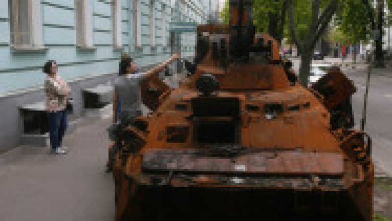 Oameni se uită la epava unui vehicul blindat rusesc instalat în fața Muzeului Național de Istorie Militară al Ucrainei. Foto: Profimedia Images | Poza 8 din 13