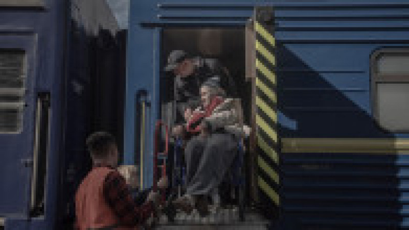 Voluntari care ajută o femeie cu handicap în gara din Povrovsk, unde oamenii urmează să fie evacuați din Kramatorsk și periferiile orașului din cauza armatei ruse. Foto: Profimedia Images | Poza 7 din 12