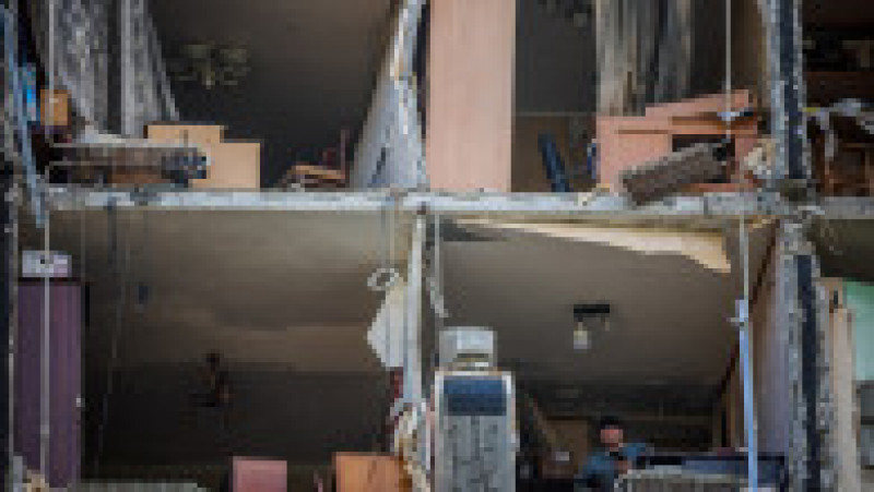 Un bărbat se uită din apartamentul său grav avariat de bombardamente în districtul Saltivka, la nordul de Harkov. Foto: Profimedia Images | Poza 6 din 12