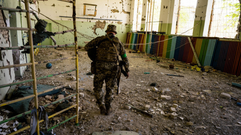 Un soldat inspectează sala de sport a unei școli din Luch, un sat de la granița dintre Nicolaev cu regiunea Herson. Foto: Profimedia Images

