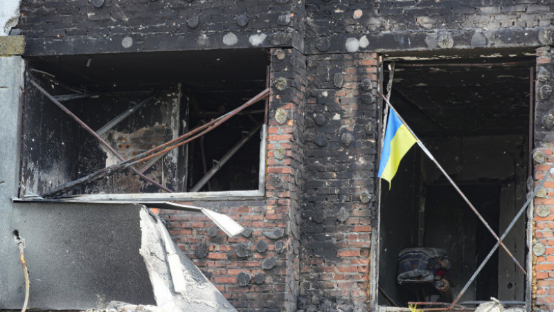 Un steag ucrainean rezistă în fața unei clădiri distruse în Mariupol. Foto: Profimedia Images
