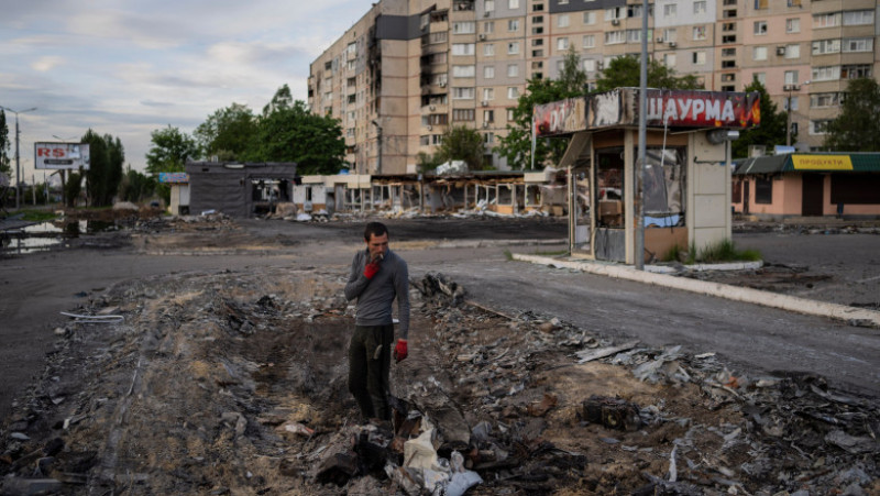 Un bărbat caută resturi de metal într-un cartier bombardat din Harkov. Foto: Profimedia Images