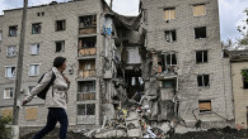 O femeie trece pe lângă un bloc de apartamente distrus din Bakhmut, în regiunea Donbas. Foto: Profimedia Images | Poza 17 din 22