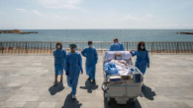 BARCELONA, SPAIN - JUNE 03: Hospital patient Isidre Correa is taken to the seaside by intensive heath care staff outside the Hospital del Mar on June 03, 2020 in Barcelona, Spain. Mr Correa was taken into Intensive Care on April 14 after his coronavirus infection worsened while he had been in hospital since April 9. Today he will leave the ICU to follow his recovery at the hospital. Hospital del Mar is taking recovering COVID-19 patients from the ICU to the seaside as part of their recovering process aiming to humanize its Intensive Care Units. (Photo by David Ramos/Getty Images) | Poza 4 din 5