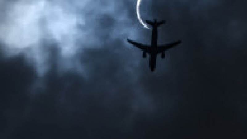 Un avion trece pe cerul pe care poate fi văzuta eclipsa parțială de Soare, 21 iunie 2020. Foto: Profimedia | Poza 9 din 9