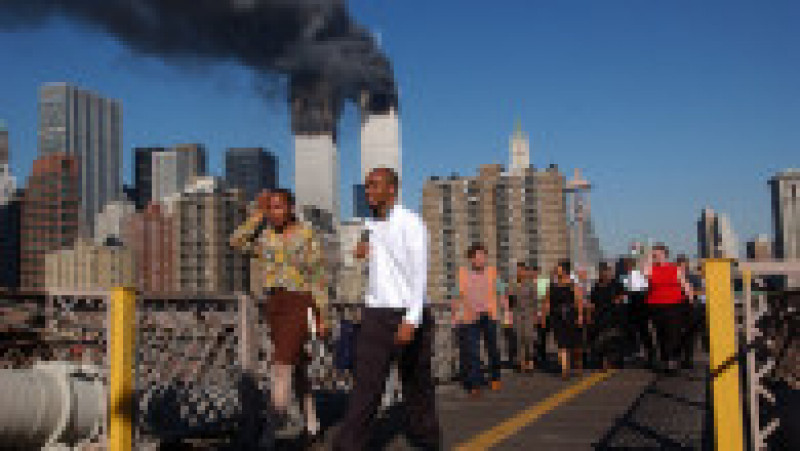394261 159: People walk over the Brooklyn Bridge as the world trade center burns September 11, 2001 after two hijacked airplanes slammed into the twin towers in New York City. (Photo by Spencer Platt/Getty Images) | Poza 3 din 19