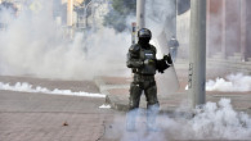Un polițist care participă la intervenția forțelor de ordine stă în mijlocul fumului de la gazele de lacrimogene. Foto: Guillermo Legaria/ Getty Images | Poza 3 din 4