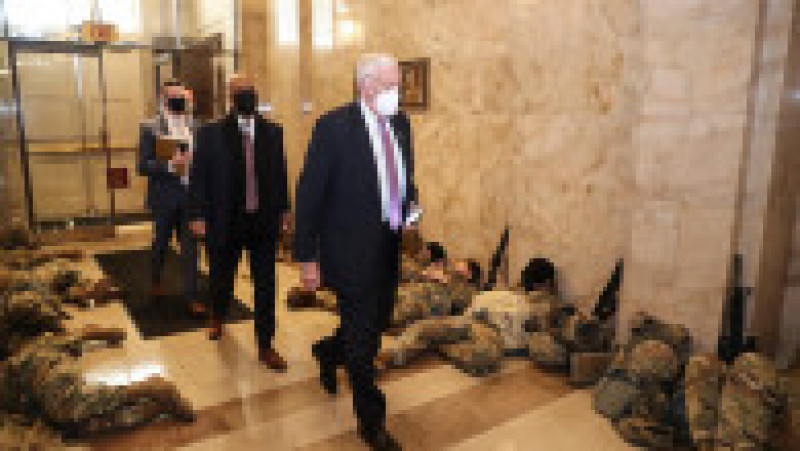 Membri ai Camerei Reprezentanţilor SUA merg printre soldaţi ai Gărzii Naţionale care dorm pe podelele Capitoliului SUA. Foto: Profimedia Images | Poza 42 din 45