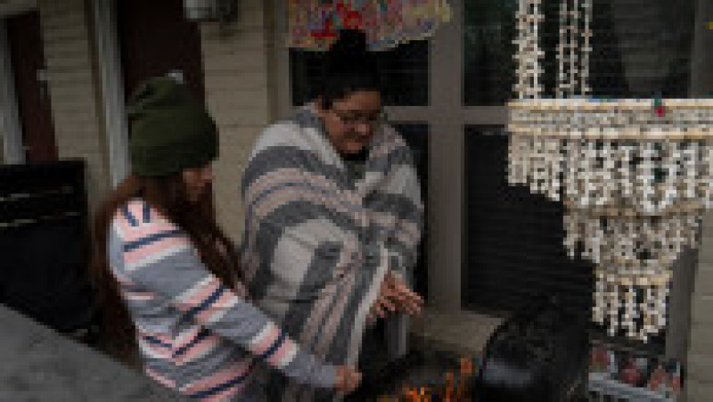 Karla Perez și Esperanza Gonzalez se încălzesc la grătar, neavând altă sursă de căldură în casă Foto: Profimedia | Poza 3 din 4