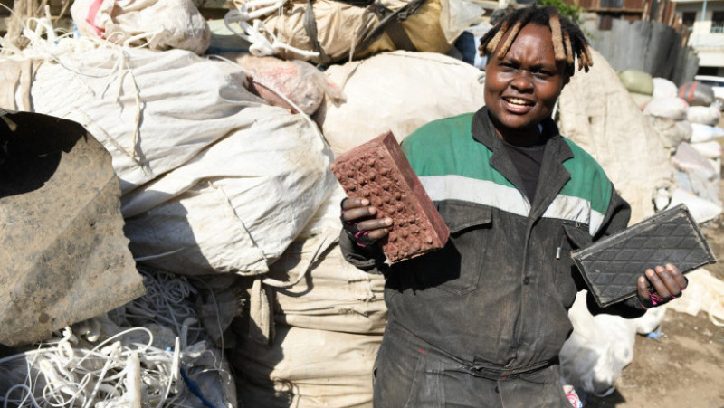 Tânăra din Kenya care reciclează plasticul tine in maini doua caramizi. Foto: Profimedia Images