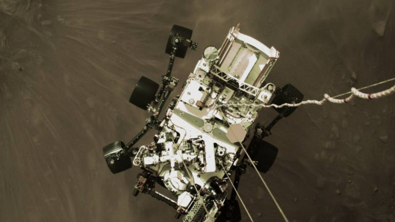 Perseverance, atașat cu cabluri de modulul care l-a coborât pe suprafața planetei Marte. Foto: NASA.gov