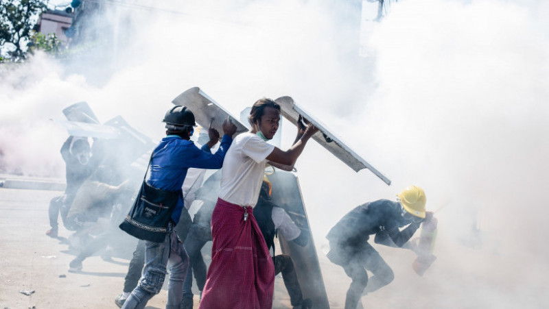 Manifestanții se apără de gazele lacrimogene lansate de forțele de ordine. Sursa foto: Profimedia Image