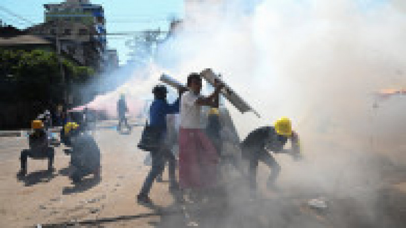 Manifestanții se apără de gazele lacrimogene lansate de forțele de ordine. Sursa foto: Profimedia Image | Poza 9 din 16