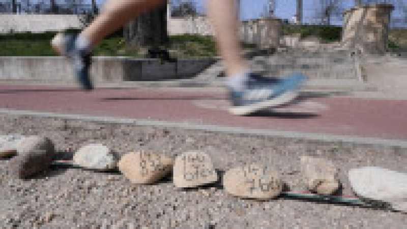 Un alergator trece pe lângă cele 20.000 de pietre aliniate de-a lungul unei alei de pe Insula Margareta din Budapesta, pentru a comemora cele 20.000 de victime COVID din Ungaria înregistrate până la 2 aprilie 2021 Foto: Profimedia | Poza 6 din 8