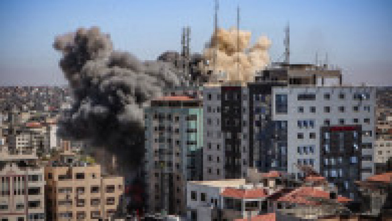 Fumul se ridică în timp ce clădirea Al-Jalaa începe să se năruie în urma bombardamentului israelian Foto: Profimedia | Poza 1 din 3