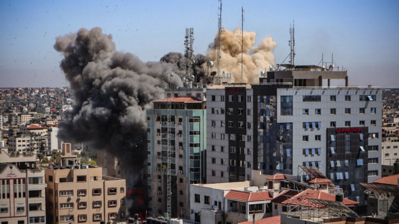 Fumul se ridică în timp ce clădirea Al-Jalaa începe să se năruie în urma bombardamentului israelian Foto: Profimedia