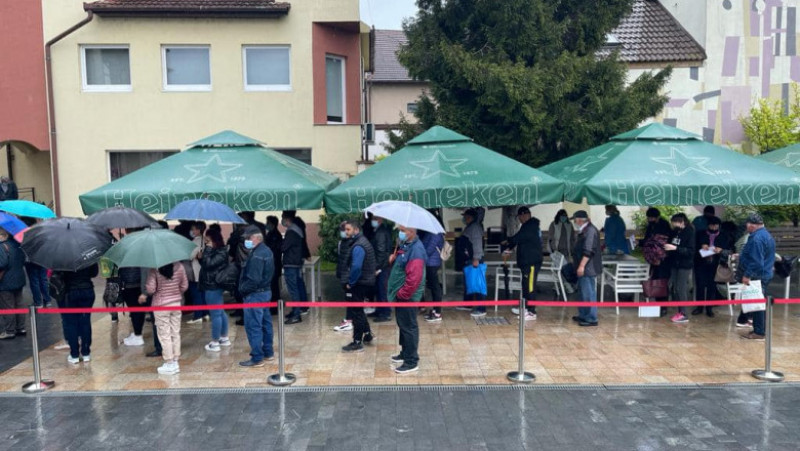 Zeci de oameni așteaptă în ploaie să se vaccineze împotriva COVID-19 în Blaj, județul Alba. Foto: Alexandru Sinea/ Facebook