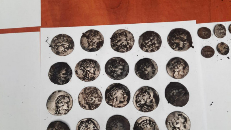 Monede antice descoperite sub pământ, într-un vas de ceramică. Foto: Poliția Română