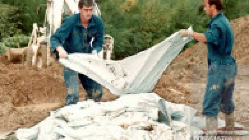 Anchetatorii Tribunalului Internațional pentru Crime de Război scot un sac de rămăsițe umane dintr-o groapă comună, aflată lângă satul Pilica din Bosnia. În acea groapă au fost găsite peste 100 de cadavre. Sursa foto: Profimedia Images | Poza 17 din 26