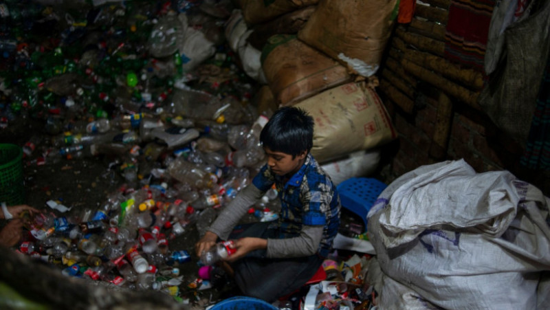 Copil din Bangladesh care lucreză la o fabrică de reciclare a plasticului. Foto: Profimedia