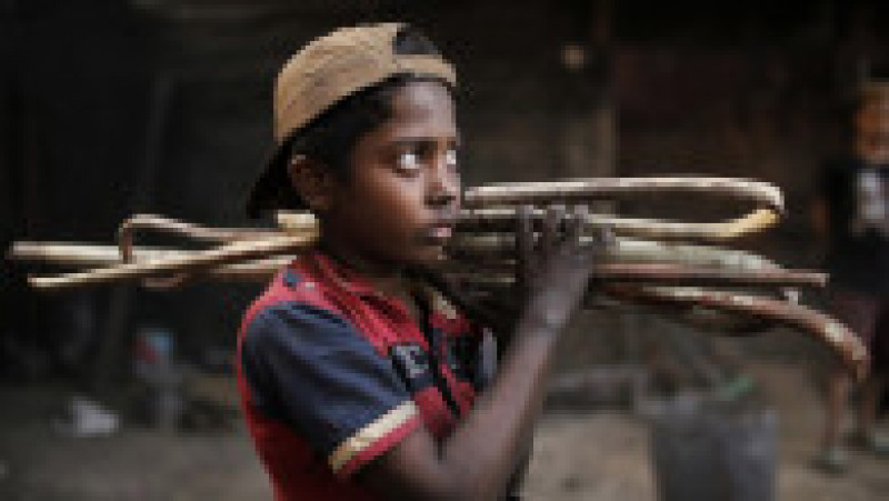 Copil din Bangladesh care cară pe umeri bețe din fier. Foto: Profimedia | Poza 3 din 9