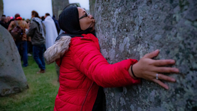 O femeie sărută piatra monumentului de la Stonehenge. Foto: Profimedia