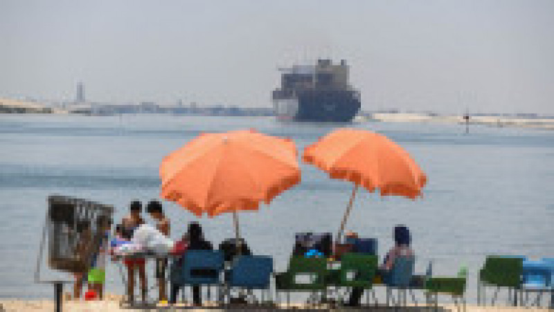 Tineri adunați pe malul Canalului Suez, pe 27 martie 2021, când nava Ever Given încă era blocată. Egiptul a pierdut până la 15 milioane de dolari pentru fiecare zi de blocaj. Sursa foto: Profimedia | Poza 4 din 11