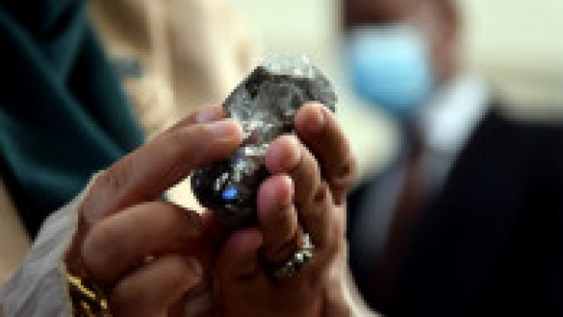 Un membru al guvernului din Botswana ține în mână diamantul de 1.174 de carate descoperit de compania Lucara în Botwsana. Sursa foto: Profimedia Images | Poza 5 din 8