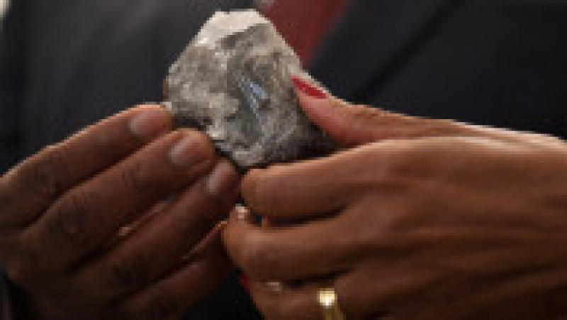 Un membru al guvernului din Botswana ține în mână diamantul de 1.174 de carate descoperit de compania Lucara în Botwsana. Sursa foto: Profimedia Images | Poza 2 din 8