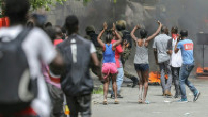 Oamenii ard cauciucuri în timp ce secția de poliție Petionville este înconjurată. Sursa foto: Profimedia Images | Poza 7 din 26