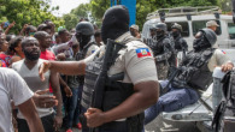 Poliția urmărește mulțimea care începe să înconjoare secția Petionville. Sursa foto: Profimedia Images | Poza 23 din 38