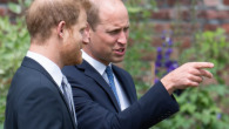 Prințul William îi arată ceva fratelui său în timp ce merg prin grădina Sunken a Palatului Kensington Foto: Profimedia | Poza 6 din 21