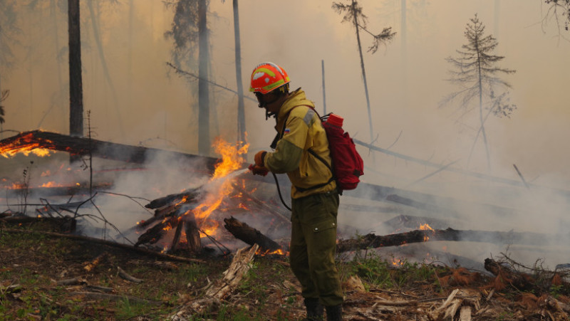Un pompier se luptă cu flăcările unui incendiu din Iacuția. Foto: Profimedia Images