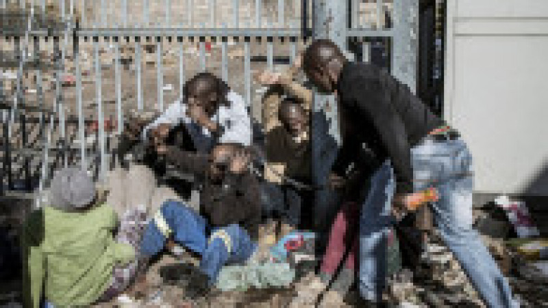 Bărbați suspectați că ar fi jefuit magazine au fost prinși și loviți de grupurile de civili înarmați, formate pentru a opri haosul din Africa de Sud. Foto: Profimedia Images | Poza 5 din 5