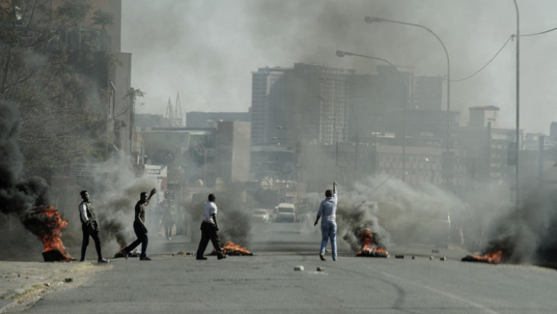 Protestatarii ard cauciucuri în Jeppestown, Johannesburg. Sursa foto: Profimedia Images
