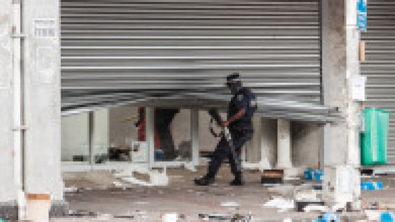 Un polițist din Durban verifică un magazin jefuit. Sursa foto: Profimedia Images | Poza 6 din 33