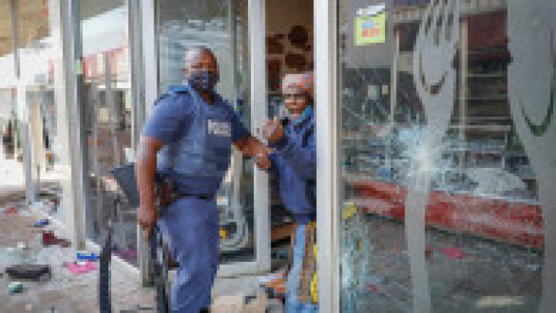 Un polițist sud-african arestează un presupus jefuitor în Lotsoho Mall din Katlehong. Sursa foto: Profimedia Images | Poza 10 din 33