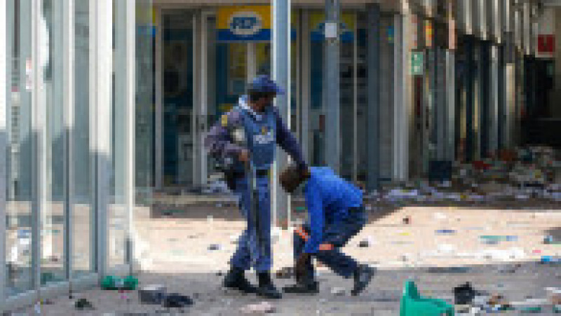Un polițist sud-african arestează un presupus jefuitor în mall-ul Lotsoho din Katlehong. Sursa foto: Profimedia Images | Poza 16 din 33