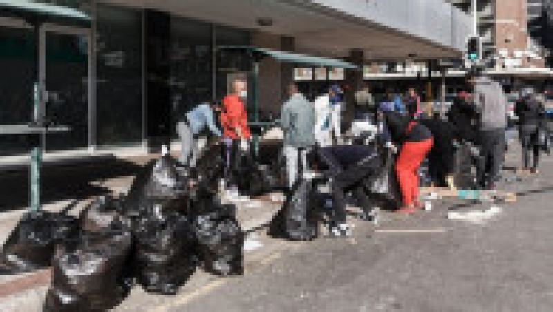 Voluntarii curăță Piața Diepkloof din Soweto, Johannesburg, după jafuri și vandalism. Sursa foto: Profimedia Images | Poza 33 din 33