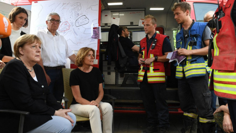 Angela Merkel stă de vorbă cu pompierii care au intervenit la inundațiile din Germania. Foto: Profimedia Images