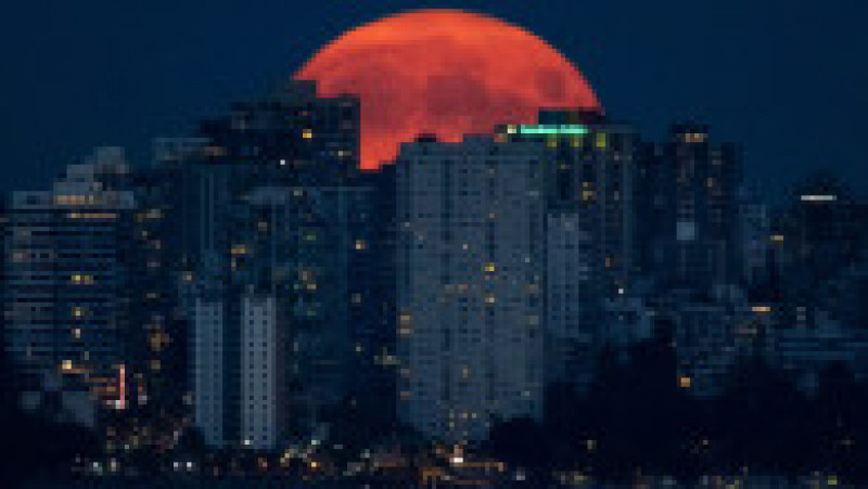 Luna plină de deasupra orașului Vancouver, Canada, are nuanțe portocalii, din cauza inendiilor de begetație. Foto: Profimedia | Poza 1 din 6